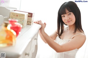 A woman in a white dress holding a book.