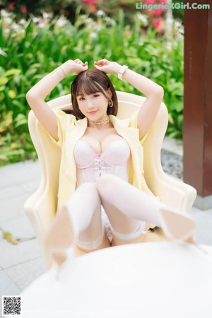 a woman in a yellow jacket and white lingerie posing for the camera