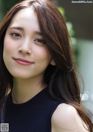 A woman with long brown hair smiling at the camera.