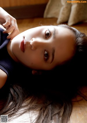 A woman in a white bra sitting on a couch.