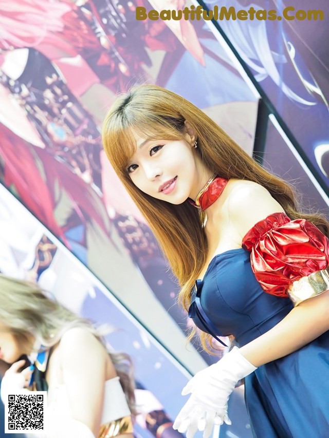 A woman in a blue dress and white gloves posing for a picture.