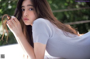 A woman with long brown hair is posing for a picture.