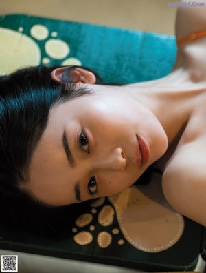 A woman laying in bed with her arms outstretched.