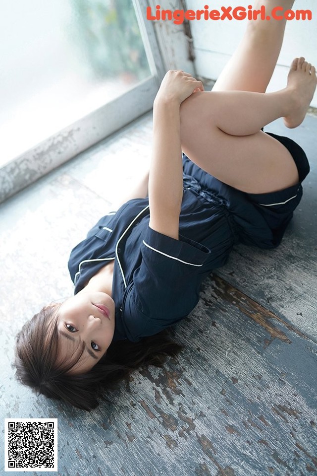 A woman laying on the floor with her legs up.