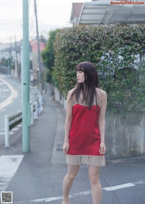 A woman with long brown hair wearing a black bra.