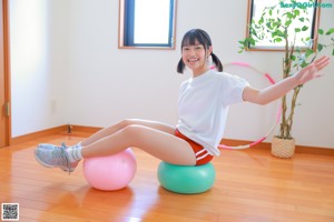 A woman in a white shirt and red shorts posing for a picture.