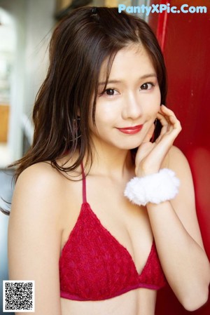 A woman in a red bikini sitting on a chair.