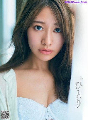 A woman in a white dress sitting on the ground.