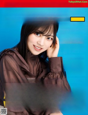 A woman in a brown dress with a blue background.