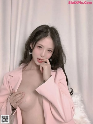 a woman in a pink jacket and panties posing for a picture