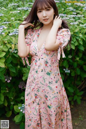 A woman in a pink robe is posing for a picture.