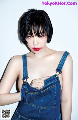 A woman in a black shirt and white socks holding a pair of chopsticks.