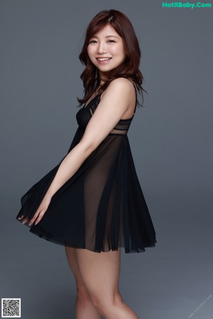 A woman in a black dress posing for a picture.