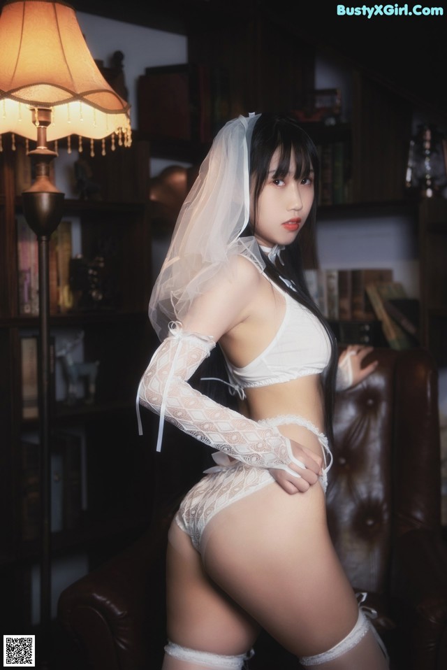 A woman in a white lingerie posing for a picture.