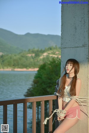 A woman in a blue and white polka dot bikini posing for a picture.