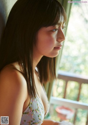 A woman standing in the middle of a lush green forest.