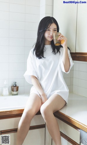 A woman with long black hair wearing a blue sweater.