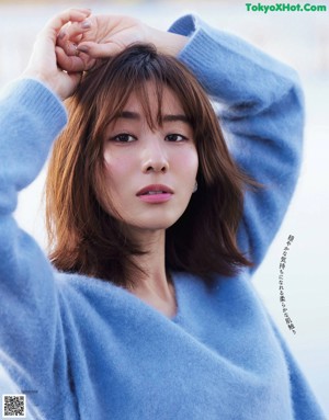 A woman in a black dress is posing for a magazine.