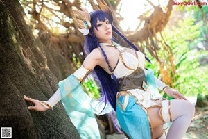 A woman dressed in a blue and white outfit holding a sword.