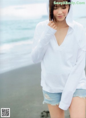 A woman in a white sweater is posing for a picture.