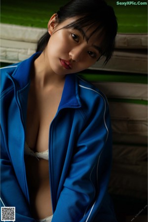 A woman laying on a bed wearing a gray bra.