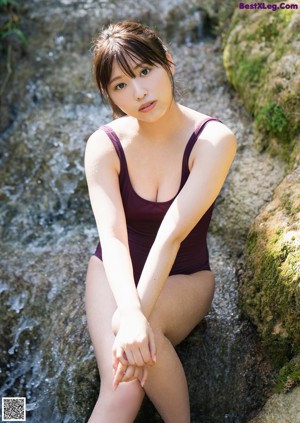 A woman in a bikini posing on the beach.