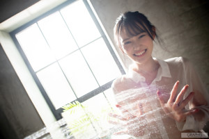 A woman in a white shirt is taking a shower.