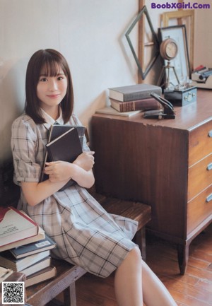 A woman laying on the floor next to a book and a teddy bear.