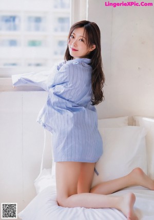 A woman in a pink sweater is posing for a picture.