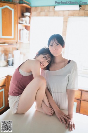 A couple of women laying on top of a green carpet.