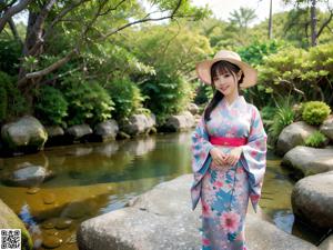 A woman in a blue kimono holding an umbrella.