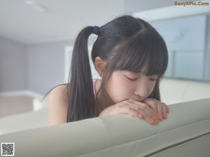 A woman sitting on top of a white couch.