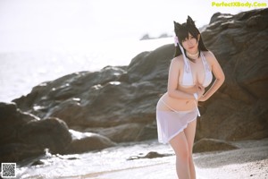 A woman in a bikini sitting on a beach.