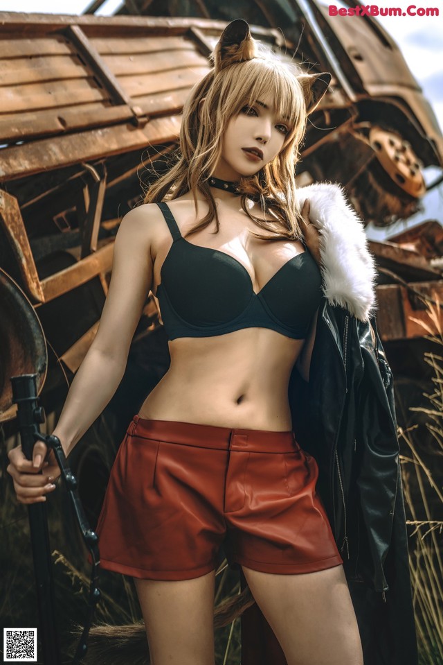 A woman in a black bra top and red shorts posing for a picture.