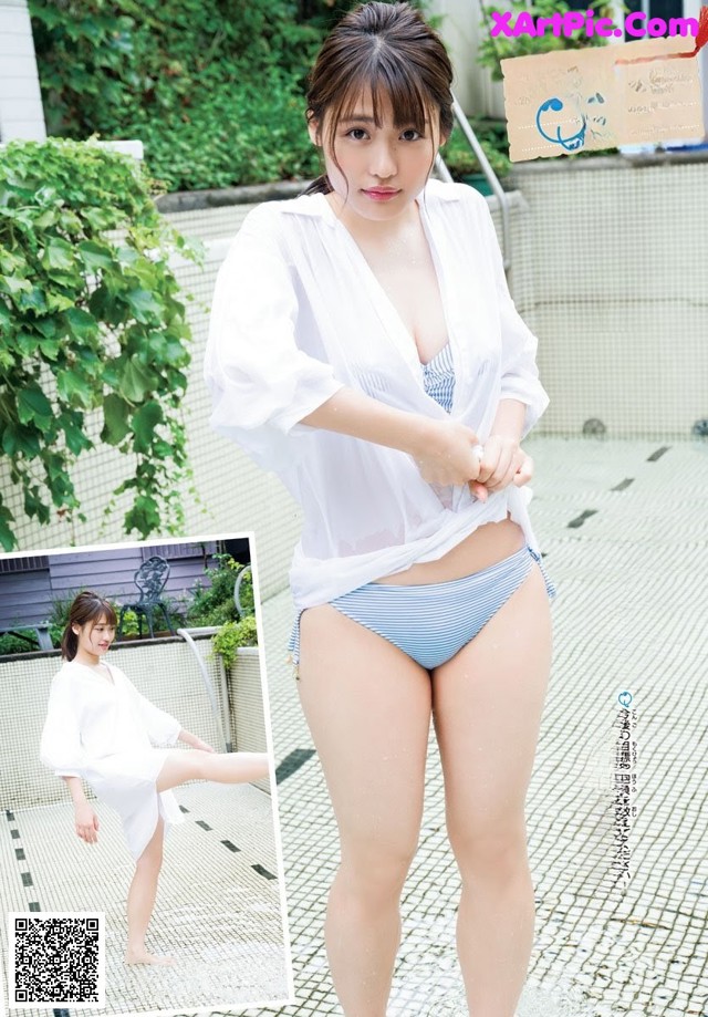 A woman in a white shirt and blue and white striped bikini.