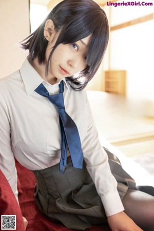 A woman in a school uniform eating a sandwich.