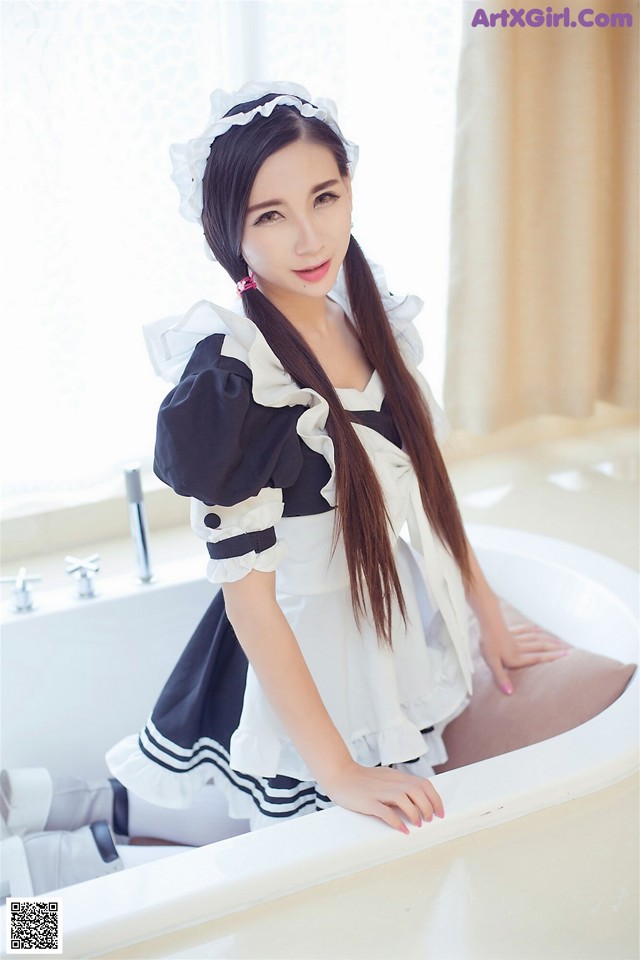 A woman in a maid outfit sitting in a bathtub.