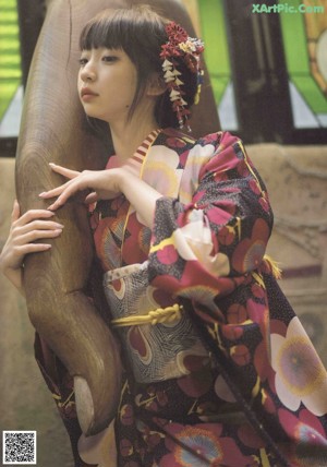 A woman in a black dress sitting on a window sill.