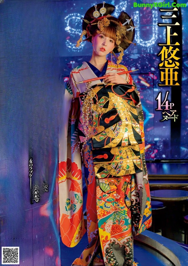 A woman in a kimono standing in front of a stage.